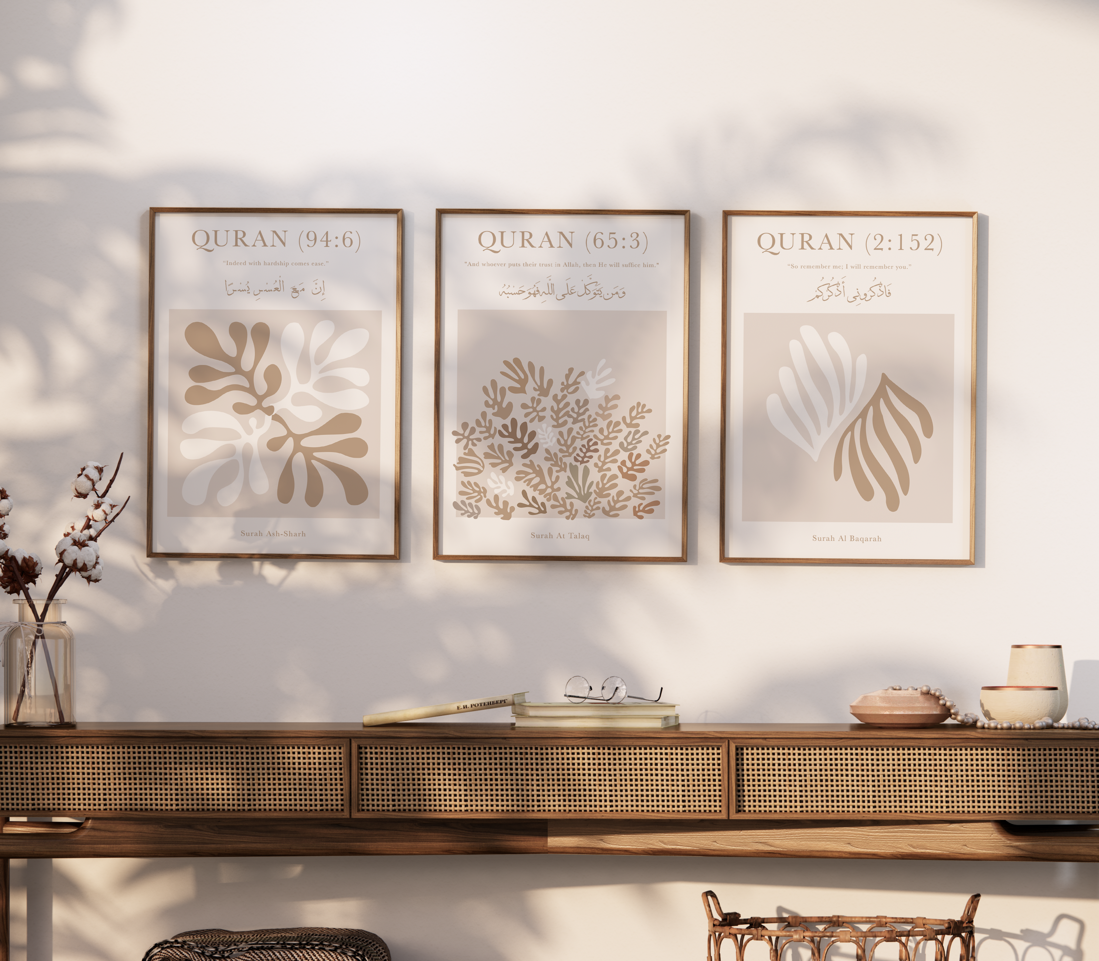 Three framed prints on a wall above a wooden console table with decorative items.